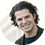 Smiling man with dark hair wearing a black shirt.