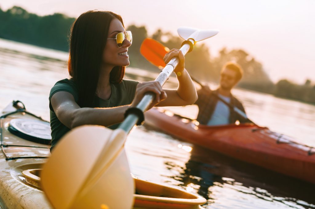 Woman kayaking with partner on a serene river.