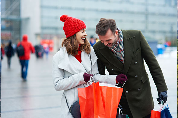 Couple with shopping bags enjoying winter sale outdoors.