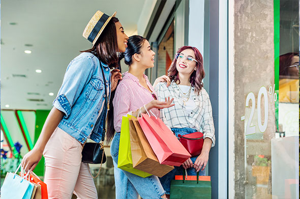 Friends shopping and enjoying a sale at a store.