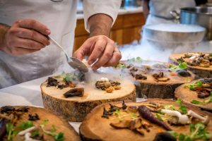 Chef preparing gourmet dishes with dry ice presentation.